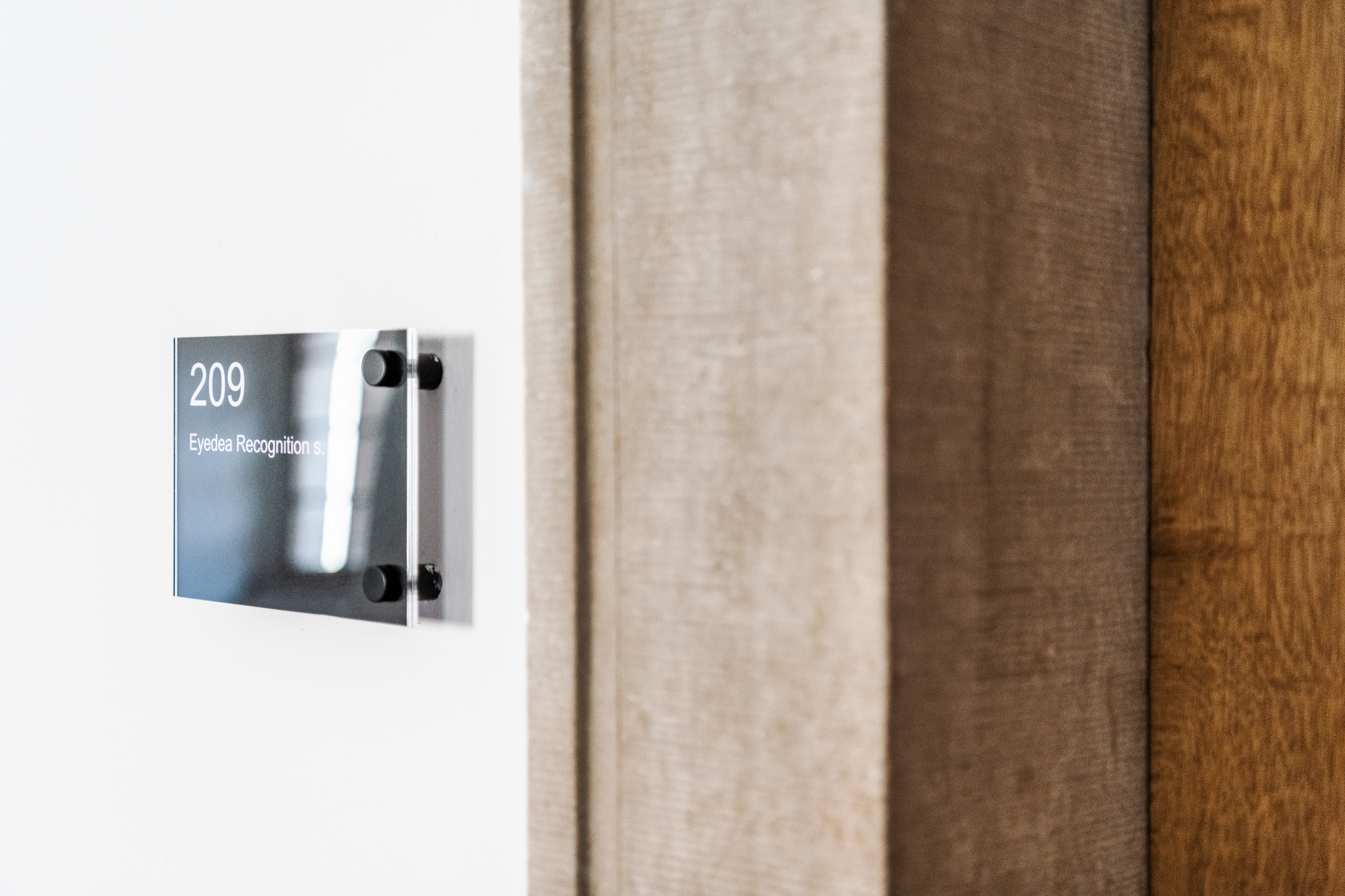 The room sign at Emmaus Abbey is displayed in a clear, minimalist style as part of the abbey's typographic-focused, easily replaceable navigation system.